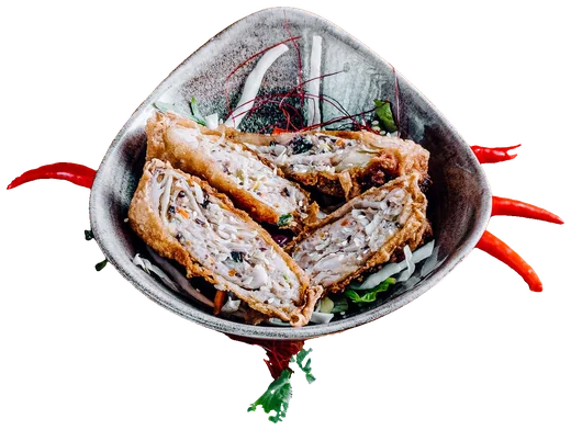 Aufgeschnittene Frühlingsrollen in einer Steingutschale, von oben